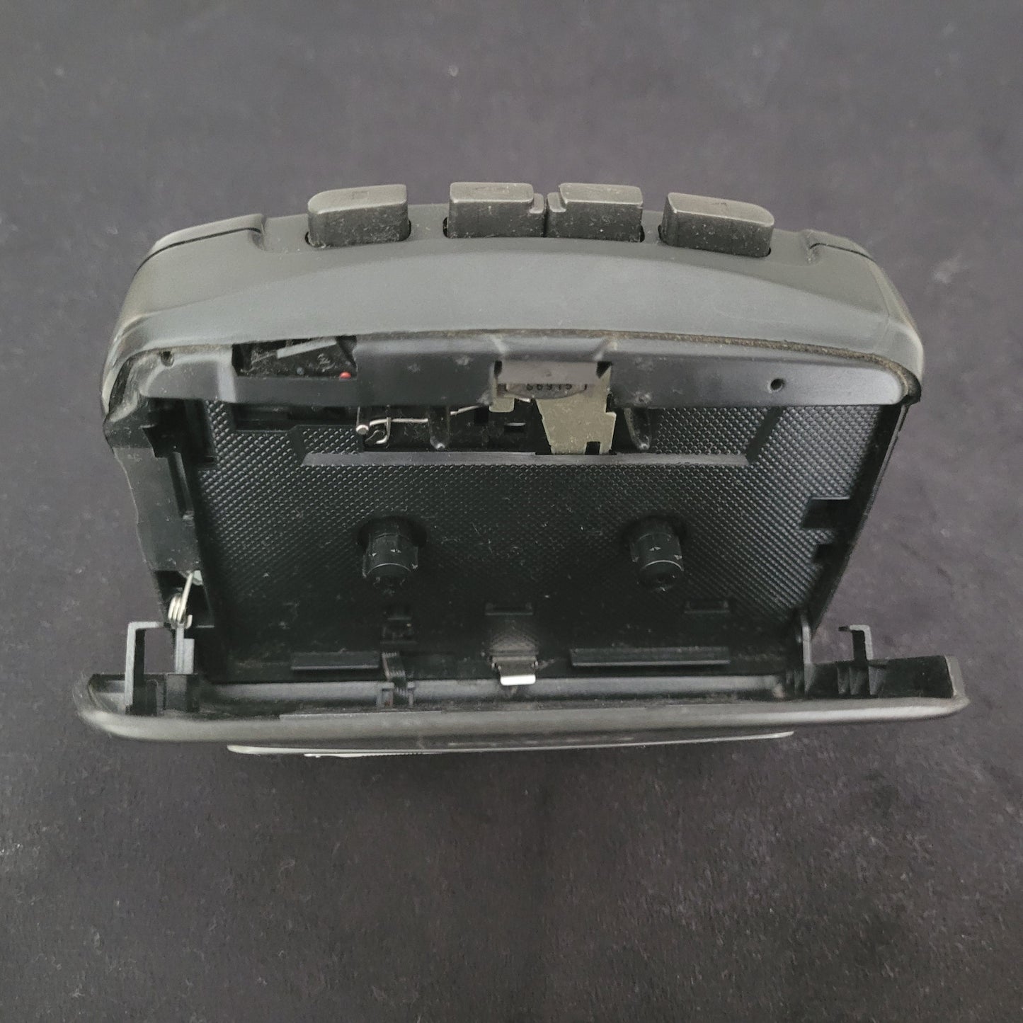 Nahaufnahme eines geöffneten Vintage-Kassettenspielers mit sichtbaren mechanischen Komponenten und Bedientasten – detaillierter Blick ins Innere klassischer Audiotechnik für Retro- und Technikliebhaber.