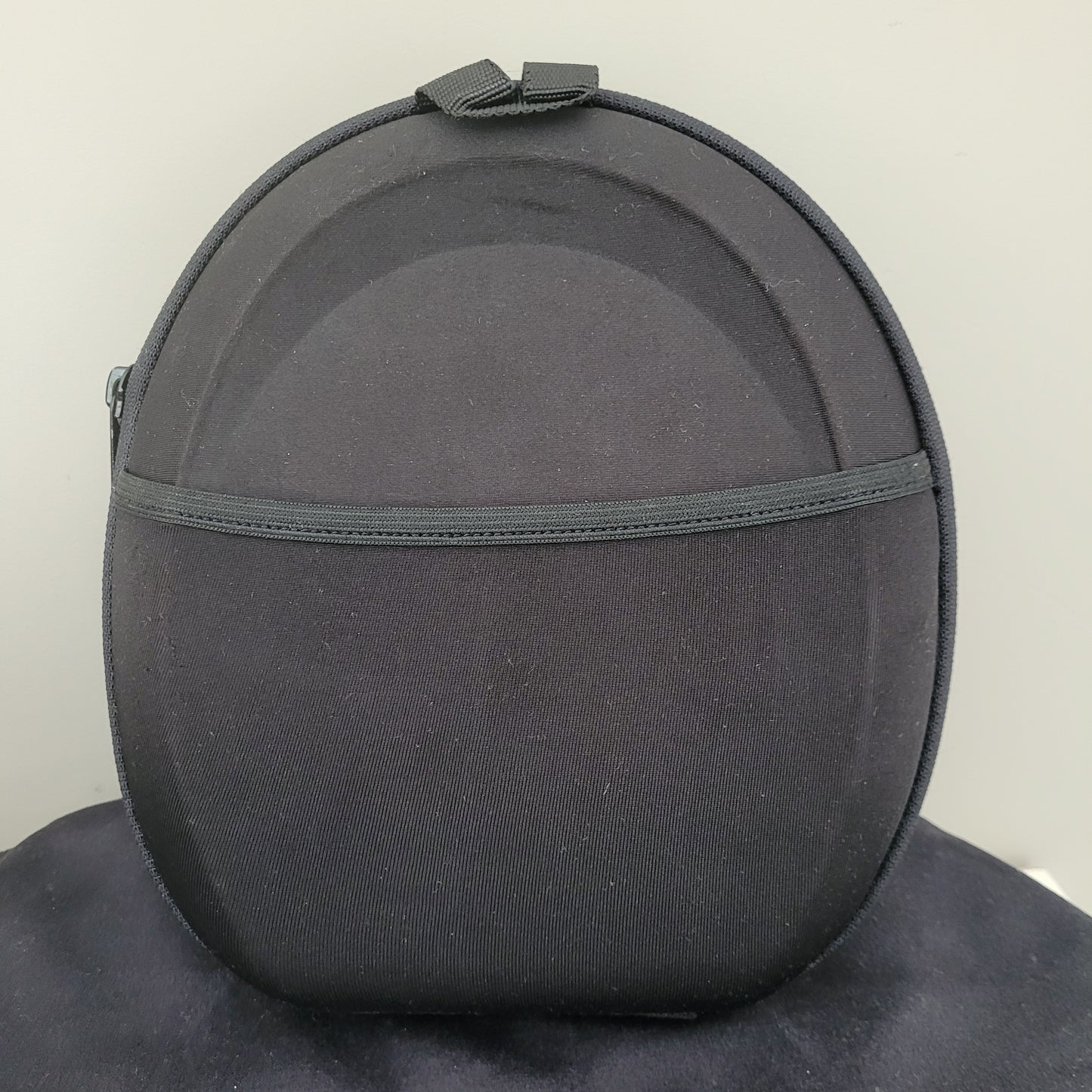 Die Rückseite der Tragetasche des Bose Kopfhörer QuietComfort 15 ist auf dunklem Hintergrund zu sehen. Die hochwertige schwarze Oberfläche der Tasche zeigt das eingestickte Bose-Logo sowie die Aufschrift „Acoustic Noise Cancelling“. Die robuste Verarbeitung und das schlichte Design unterstreichen die Qualität dieses Vintage-Kopfhörer-Zubehörs – perfekt für Liebhaber klassischer Elektronik und Audiotechnik.