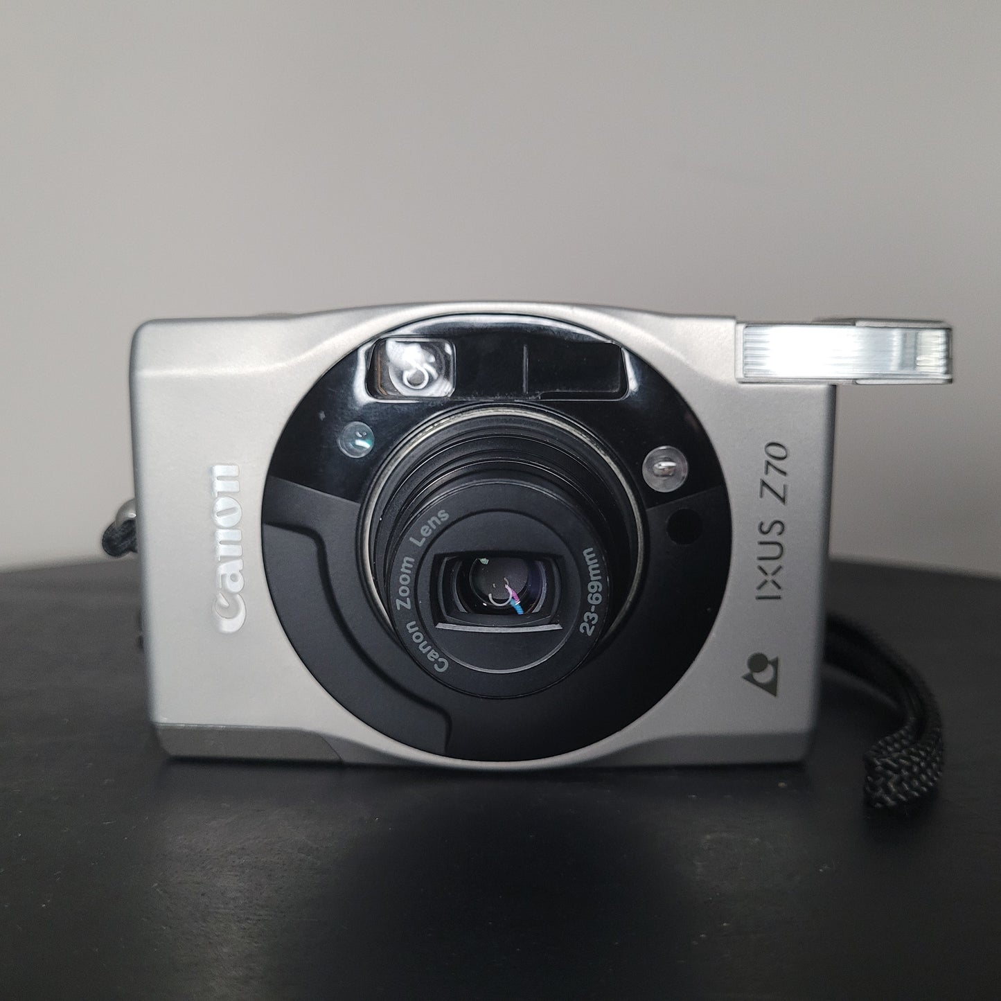 Canon IXUS Z70 Kamera in Nahaufnahme, silbernes Gehäuse mit eingebautem Blitz und Canon Zoomobjektiv 23-69mm, elegantes kompaktes Design.