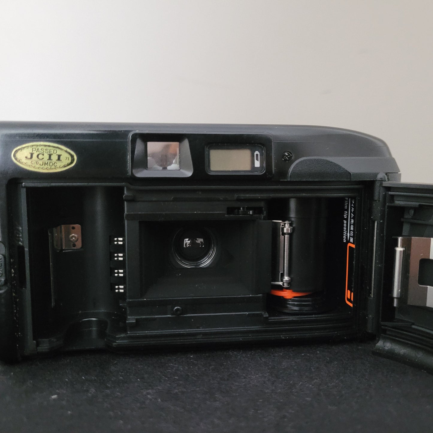 Geöffnete Rückseite einer Canon 35mm Filmkamera mit sichtbarem Filmfach, eingelegter Filmrolle und JCII-Prüfsiegel – detaillierte Innenansicht klassischer Analogtechnik für Fotografie-Enthusiasten und Sammler.