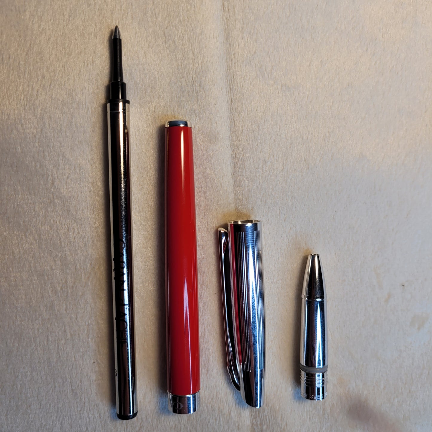 Caran d'Ache Kugelschreiber - Swiss Made, rotes Gehäuse, silberne Kappe, stilvolles Design.