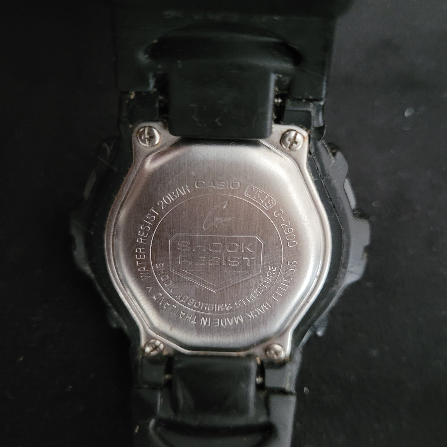 Unterseite der Casio G-Shock G-2900 Waterresist 20bar. Edelstahlrückseite mit Gravuren: Modellnummer G-2900, '20 BAR WATER RESIST', und 'SHOCK RESIST'. Robuste Vintage-Uhr.