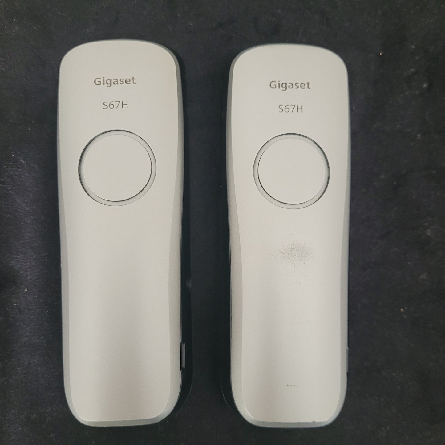 Rückseite der Gigaset Siemens S670 Duo Eco Dect Titanium Intuitive Eleganz Schnurlostelefone auf dunklem Hintergrund. Die eleganten Geräte zeigen ihr hochwertiges Titanium-Finish und die präzise Verarbeitung. Die Akkufächer und Lautsprecheröffnungen sind sichtbar, was die technische Raffinesse des DECT-Systems unterstreicht – eine stilvolle Lösung für moderne und zuverlässige Kommunikation.