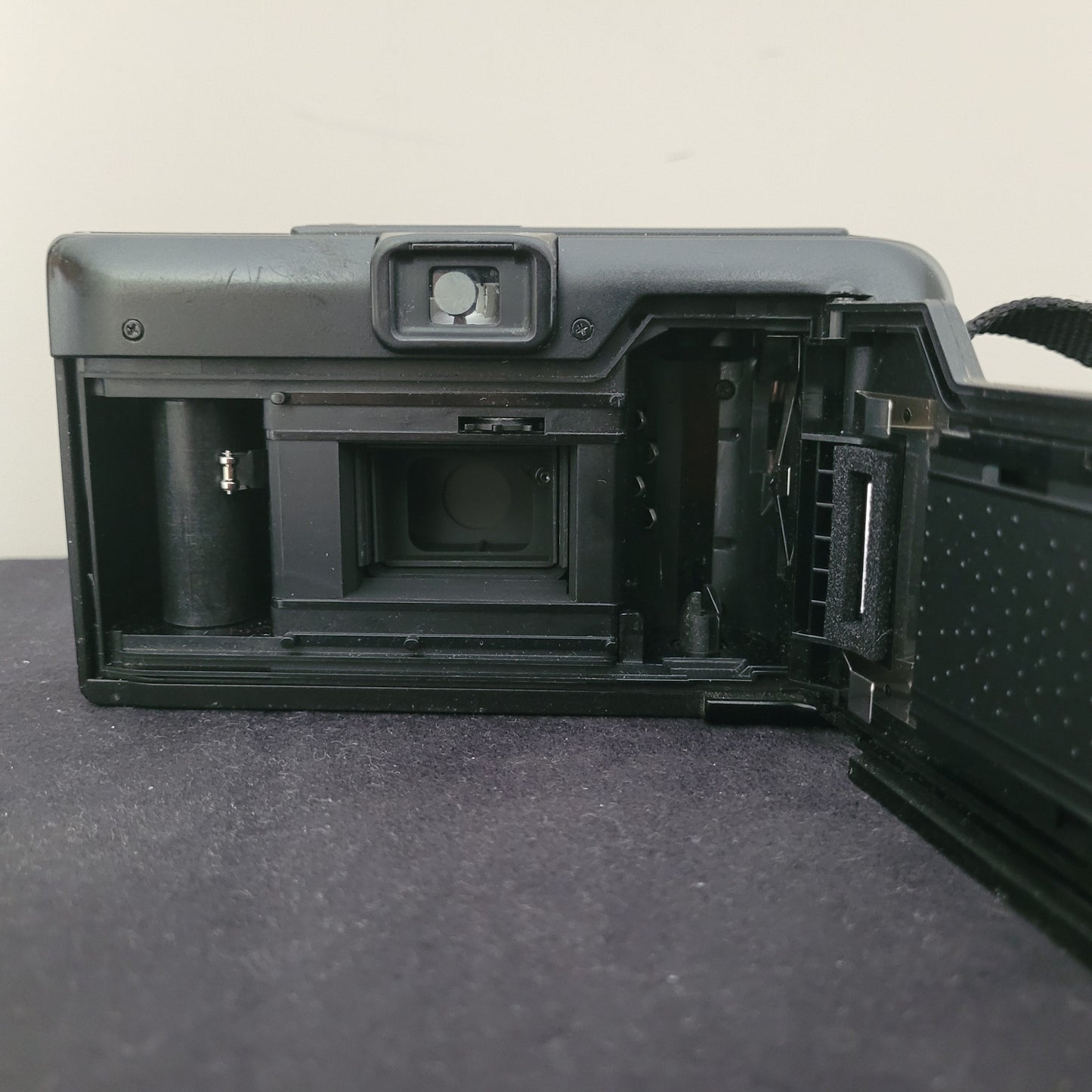 Geöffnete Rückseite der Leica Vintage Analogkamera AF-C1 mit sichtbarem Filmfach, Filmtransportspule und mechanischem Verschluss – detaillierter Blick ins Innenleben einer klassischen analogen Kompaktkamera für Retro-Fotografie und Sammler.