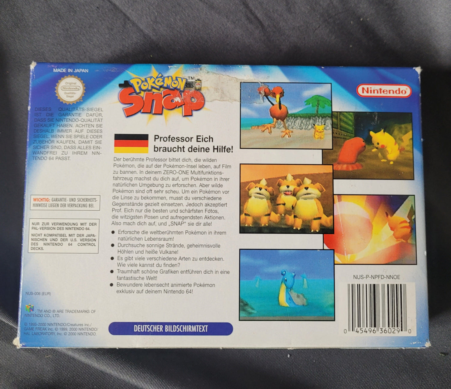 Rückseite der deutschen Originalverpackung von Pokémon Snap für Nintendo 64 – mit Spielbeschreibung zu Professor Eichs Fotoprojekt, Screenshots verschiedener Pokémon (u. a. Pikachu, Dodrio, Charmander, Electabuzz, Lapras), technischen Angaben zur N64-Kompatibilität sowie Barcode und Produktcode. Retro/Vintage Sammlerstück für N64-Fans.