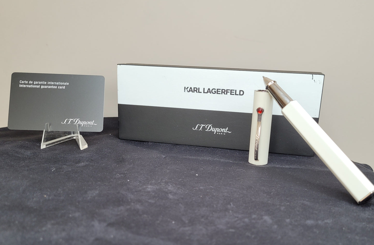 Elegantes S.T. Dupont Schreibset von Karl Lagerfeld mit weißem Kugelschreiber, roter Verzierung, Garantiekarte und schwarz-weißer Holzverpackung.