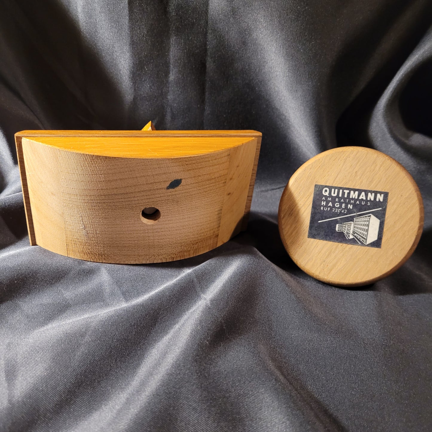 Vintage Holzobjekte – gebogenes Holzstück mit zentraler Bohrung und dunklem Fleck, handgefertigt, präsentiert auf schwarzem Hintergrund, dekoratives Sammlerstück.