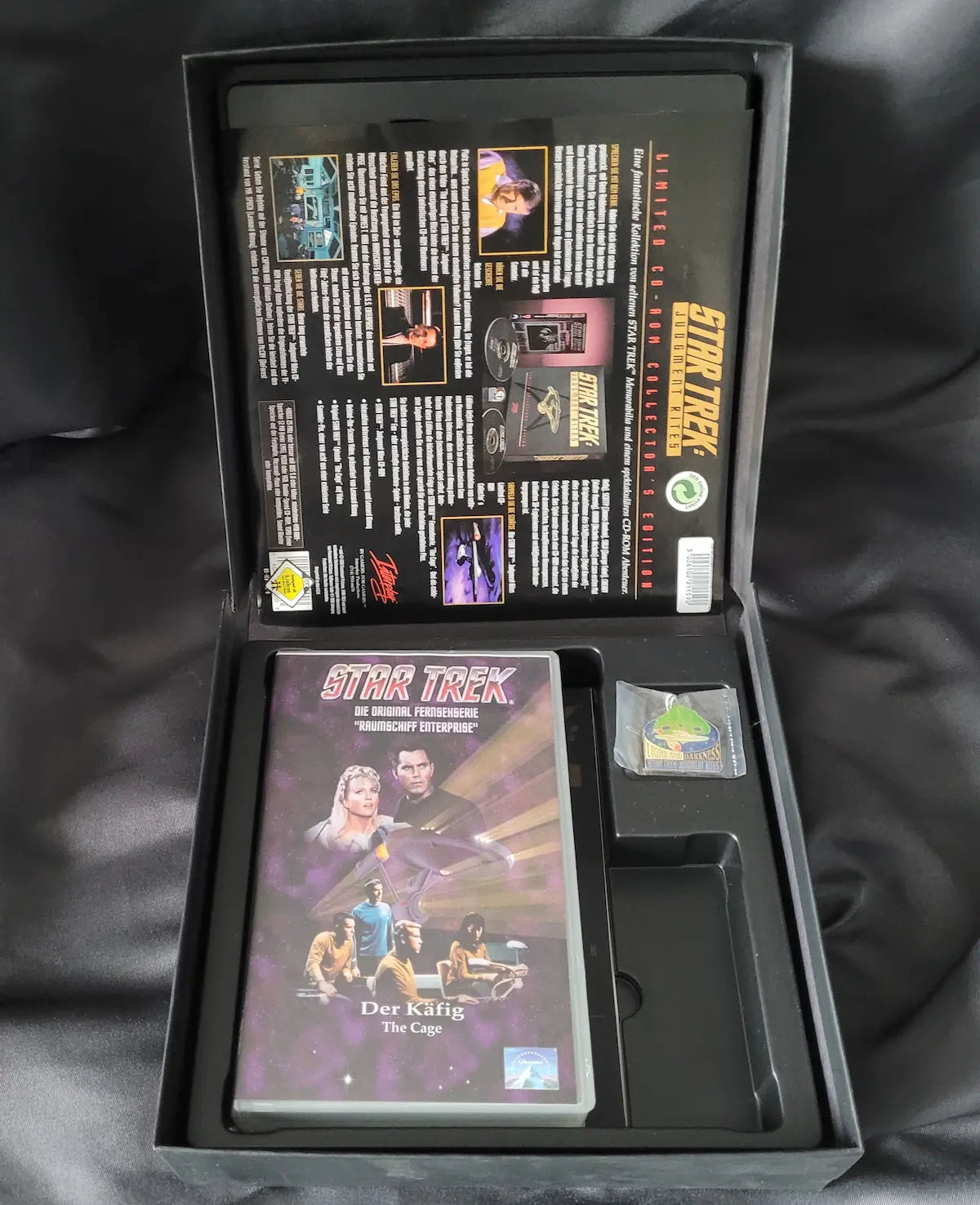 Lieferumfang der Star Trek: Judgment Rites Limited Collector's Edition mit Spielanleitung, VHS-Kassette "Der Käfig" und Sammler-Pin.
