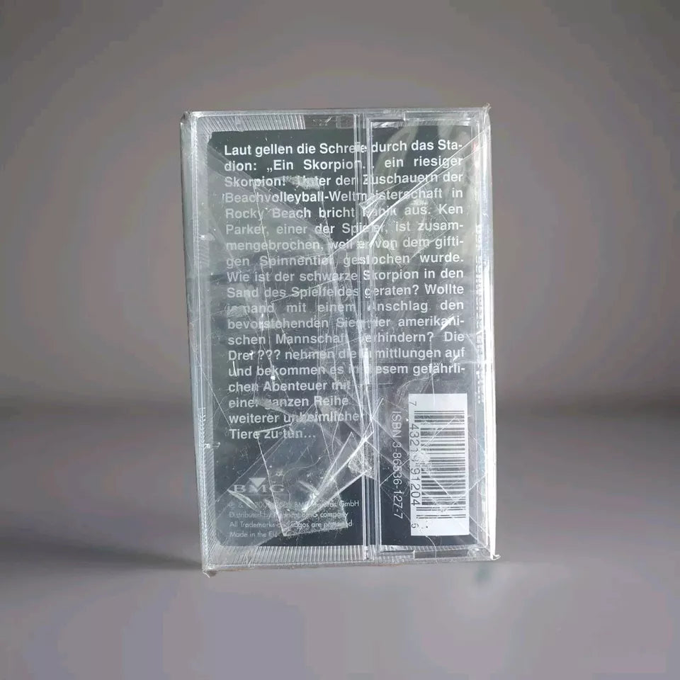 „Rückseite der Kassette 'Die drei ??? Der schwarze Skorpion', Hörspiel Nr. 120 von EUROPA. Detaillierte Beschreibung einer spannenden Szene bei der Beachvolleyball-Weltmeisterschaft mit einem riesigen Skorpion. Enthält ISBN-Nummer 3-89592-142-1.“