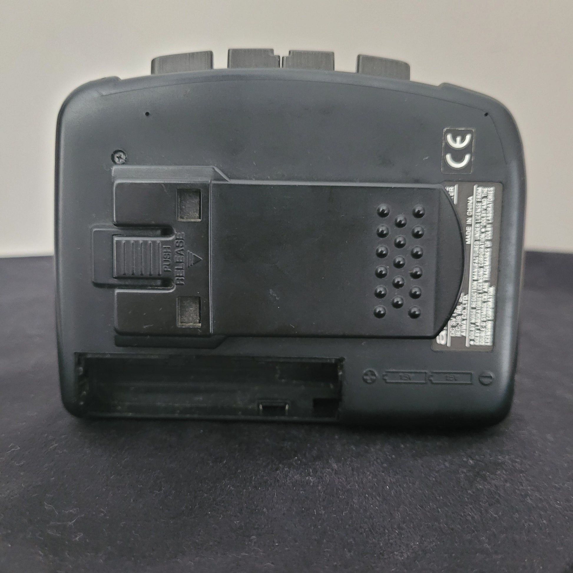 Rückseite eines Vintage-Handheld-Geräts aus schwarzem Kunststoff mit Batteriefach, EJECT-Schieber, CE-Kennzeichnung und seitlichen Bedienelementen – ideal für Retro-Fans und Sammler elektronischer Vintage-Geräte.