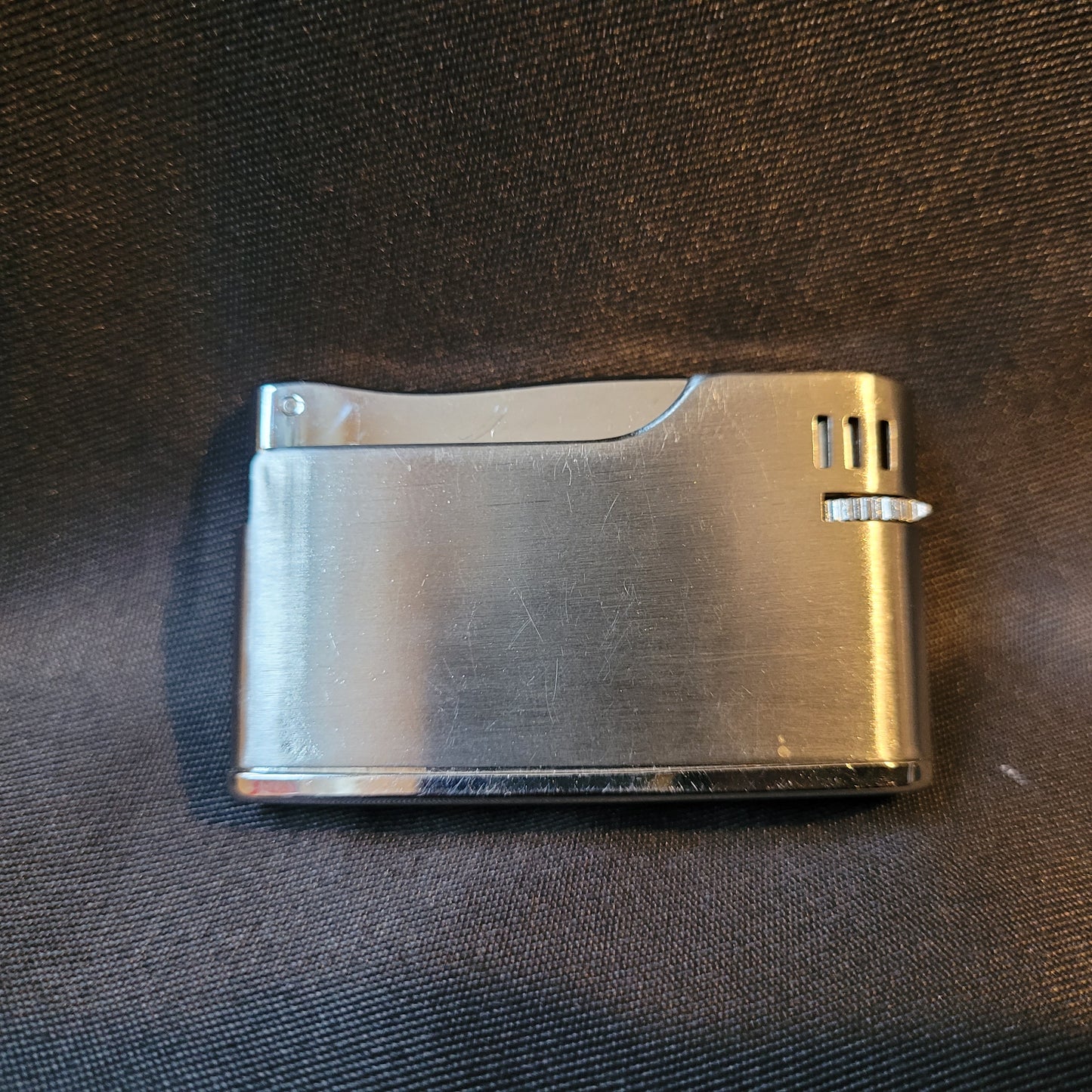 Apollo-K Feuerzeug Vintage, silberfarben, Rückseite glatt ohne Gravur, elegantes Metallgehäuse, Hintergrund schwarz, klassisches Sammlerobjekt.