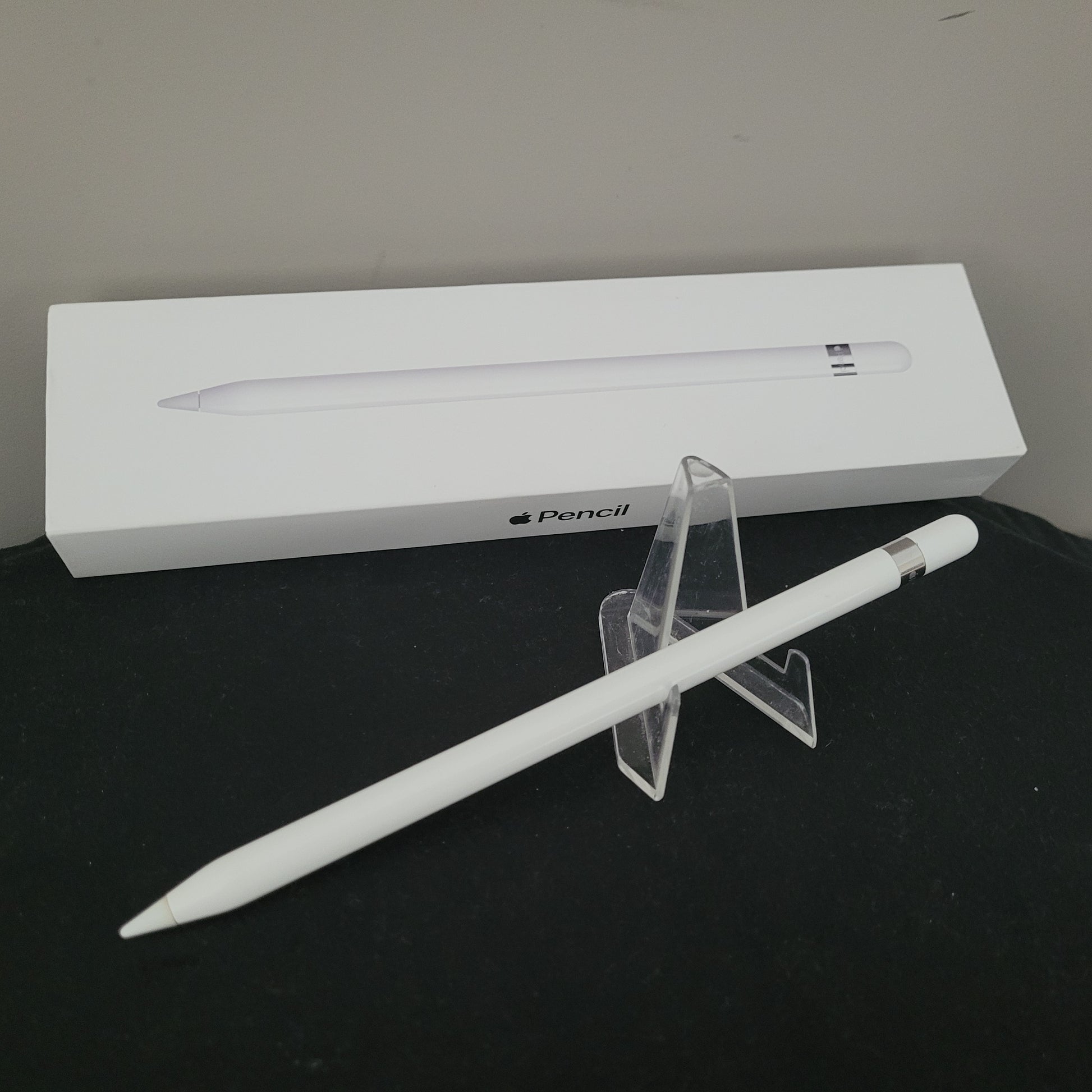 Apple Pencil Stift Original für iPad Pro – MK0C2ZM/A, liegend auf weißem Hintergrund, mit sichtbarer Schutzkappe und Lightning-Anschluss – leichte Gebrauchsspuren am Deckel erkennbar.