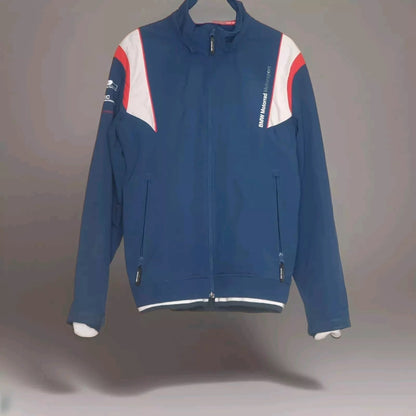 Blaue BMW Motorrad Motorsport Jacke mit Reißverschluss und weißen sowie roten Akzenten auf den Schultern, aufgehängt an einem Kleiderbügel. Ideal für Motorsport-Enthusiasten und Fans von BMW Motorrad Kleidung.