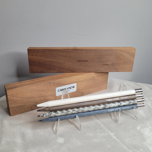 Set aus vier hochwertigen Caran d'Ache Bleistiften mit wiederverwendbaren, palladiumbeschichteten Kappen, präsentiert in einer eleganten Holzbox.