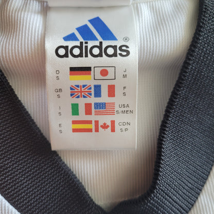 Deutschland  DFB Vintage Trikot 2002 - Größe S - Es  ist Das Logo von Adidas und verschieden Flaggen mit Kleidungsgrößen zu sehen.