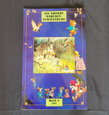 Vintage Cover des Märchenbuchs „Die große Märchenschatztruhe – Buch 4“ mit detailreichen Illustrationen klassischer Märchenfiguren wie Rotkäppchen, sprechenden Mäusen und einem Waldhaus auf tiefblauem Hintergrund mit Sternen. Das nostalgische Design und die liebevoll gestalteten Szenen machen dieses Vintage-Märchenbuch zu einem begehrten Sammlerstück für Märchenliebhaber und Fans traditioneller Kinderliteratur.