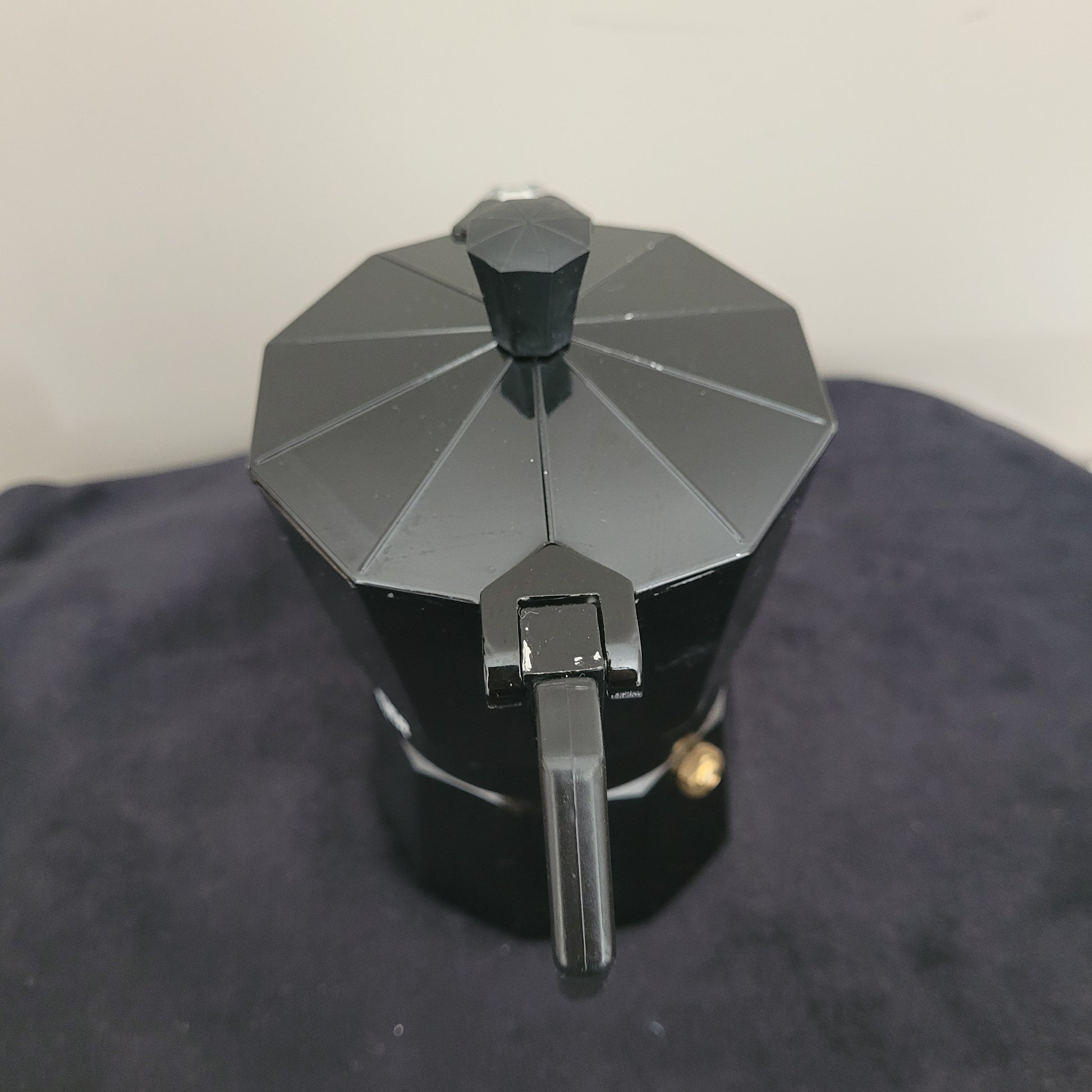 Rückansicht des eleganten Espressokochers Laura Mercier Design in Schwarz mit stilvoller sechseckiger Form und glänzendem Finish. Der schwarze Griff und Deckel unterstreichen das edle Design, während die hochwertige Verarbeitung für Langlebigkeit und optimalen Kaffeegenuss sorgt. Perfekt für stilvolle Espressozubereitung mit Laura Mercier Qualität.