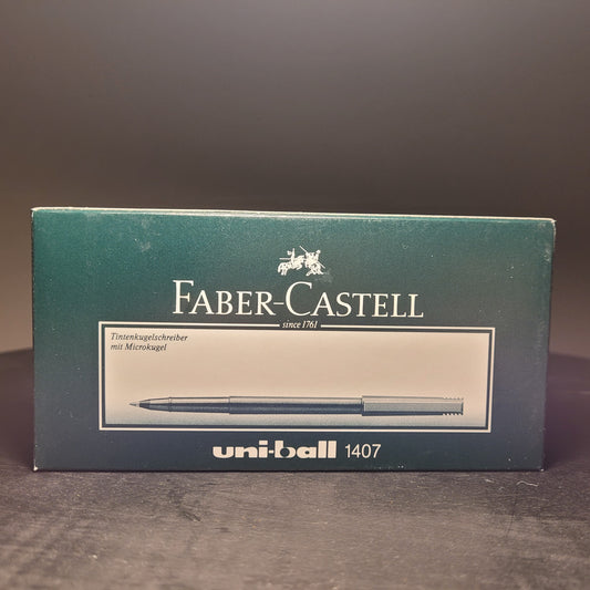 Verpackung eines Faber-Castell Tintenkugelschreibers mit Microkugel in roter Farbe. Die Verpackung ist dunkelgrün und zeigt ein Bild des enthaltenen Stifts. Oben steht 'Faber-Castell since 1761' und darunter 'Tintenkugelschreiber mit Microkugel'. Unten rechts auf der Verpackung steht 'uni-ball 1407'.