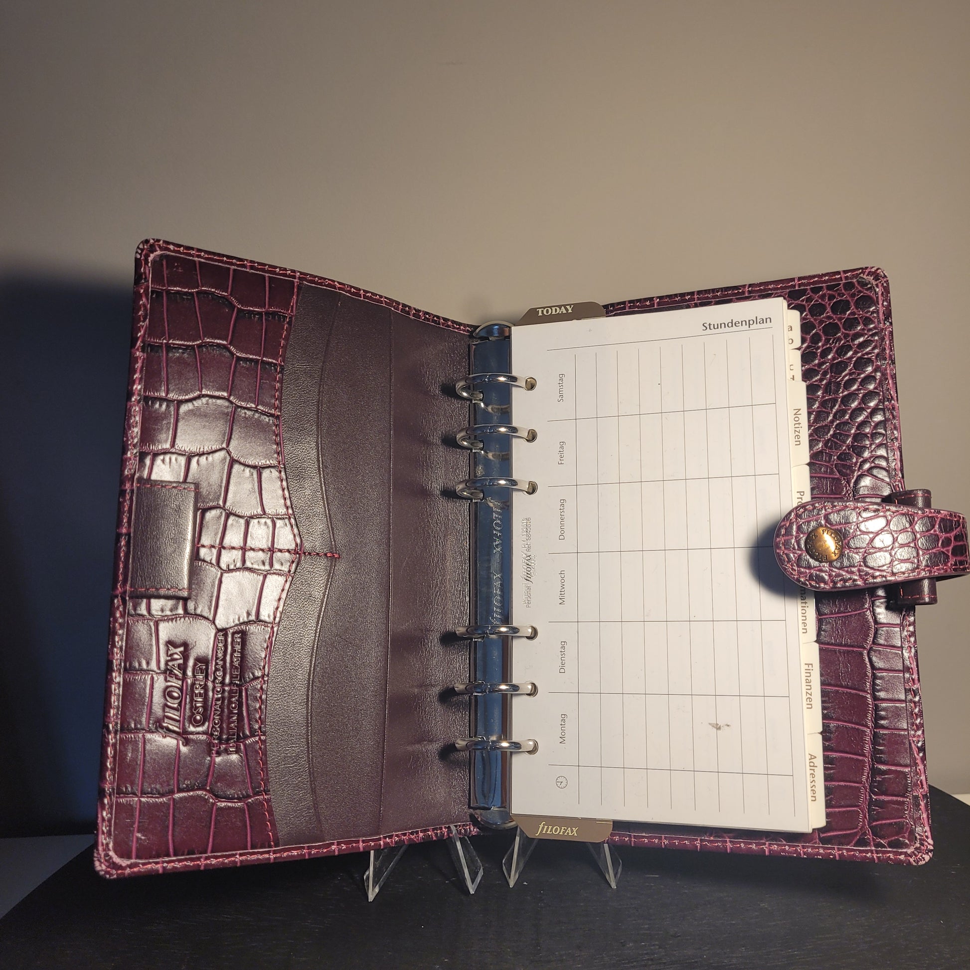Geöffneter Filofax Osterley Personal Organiser aus dunkelrotem italienischem Kalbsleder mit Krokodilleder-Optik, Wochenübersicht, Kartenfächern und Druckknopfverschluss.