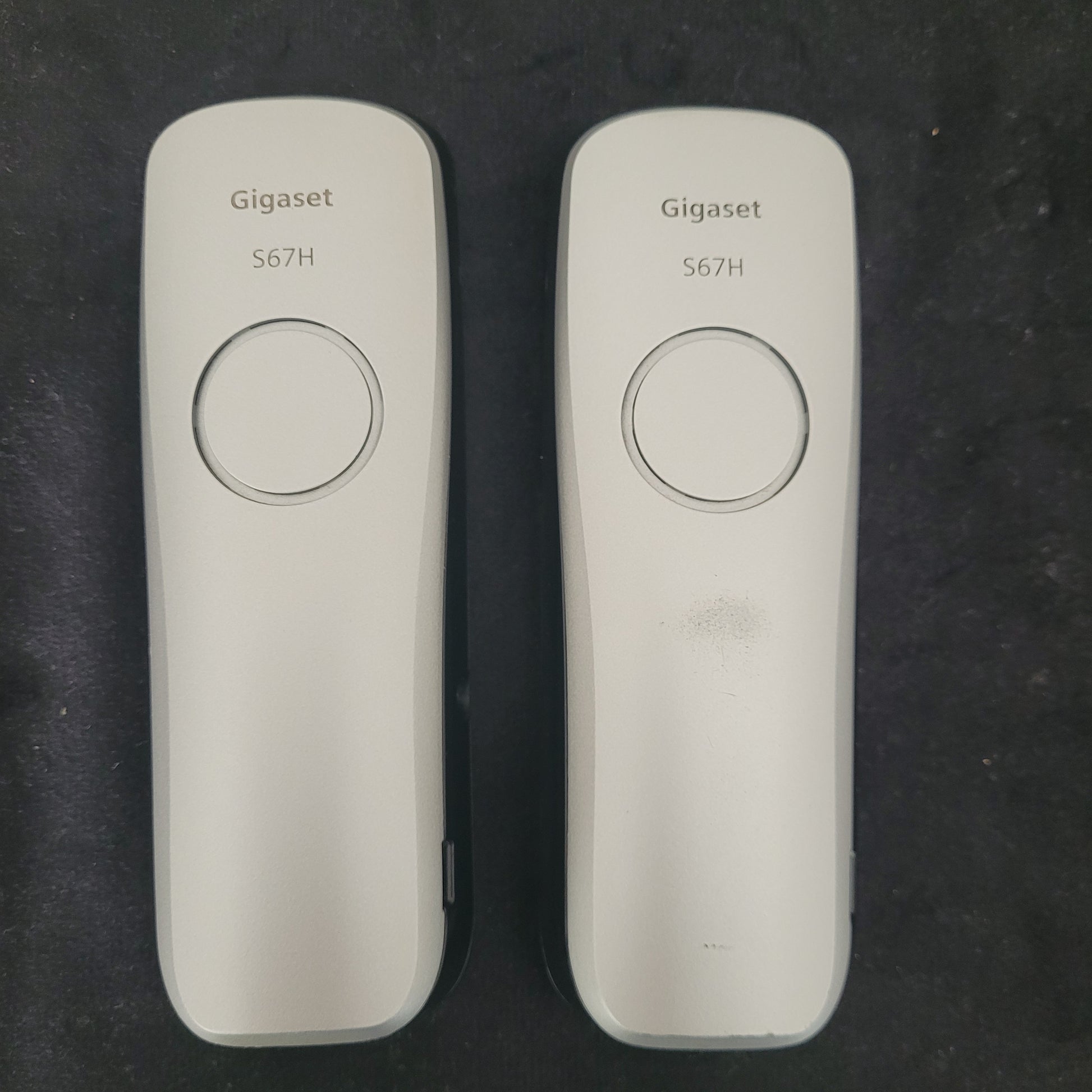 Rückseite der Gigaset Siemens S670 Duo Eco Dect Titanium Intuitive Eleganz Schnurlostelefone auf dunklem Hintergrund. Die eleganten Geräte zeigen ihr hochwertiges Titanium-Finish und die präzise Verarbeitung. Die Akkufächer und Lautsprecheröffnungen sind sichtbar, was die technische Raffinesse des DECT-Systems unterstreicht – eine stilvolle Lösung für moderne und zuverlässige Kommunikation.