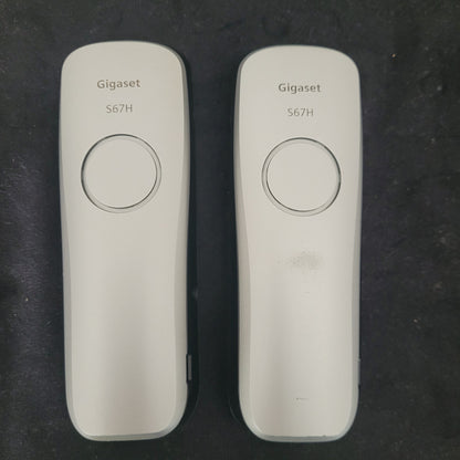 Rückseite der Gigaset Siemens S670 Duo Eco Dect Titanium Intuitive Eleganz Schnurlostelefone auf dunklem Hintergrund. Die eleganten Geräte zeigen ihr hochwertiges Titanium-Finish und die präzise Verarbeitung. Die Akkufächer und Lautsprecheröffnungen sind sichtbar, was die technische Raffinesse des DECT-Systems unterstreicht – eine stilvolle Lösung für moderne und zuverlässige Kommunikation.