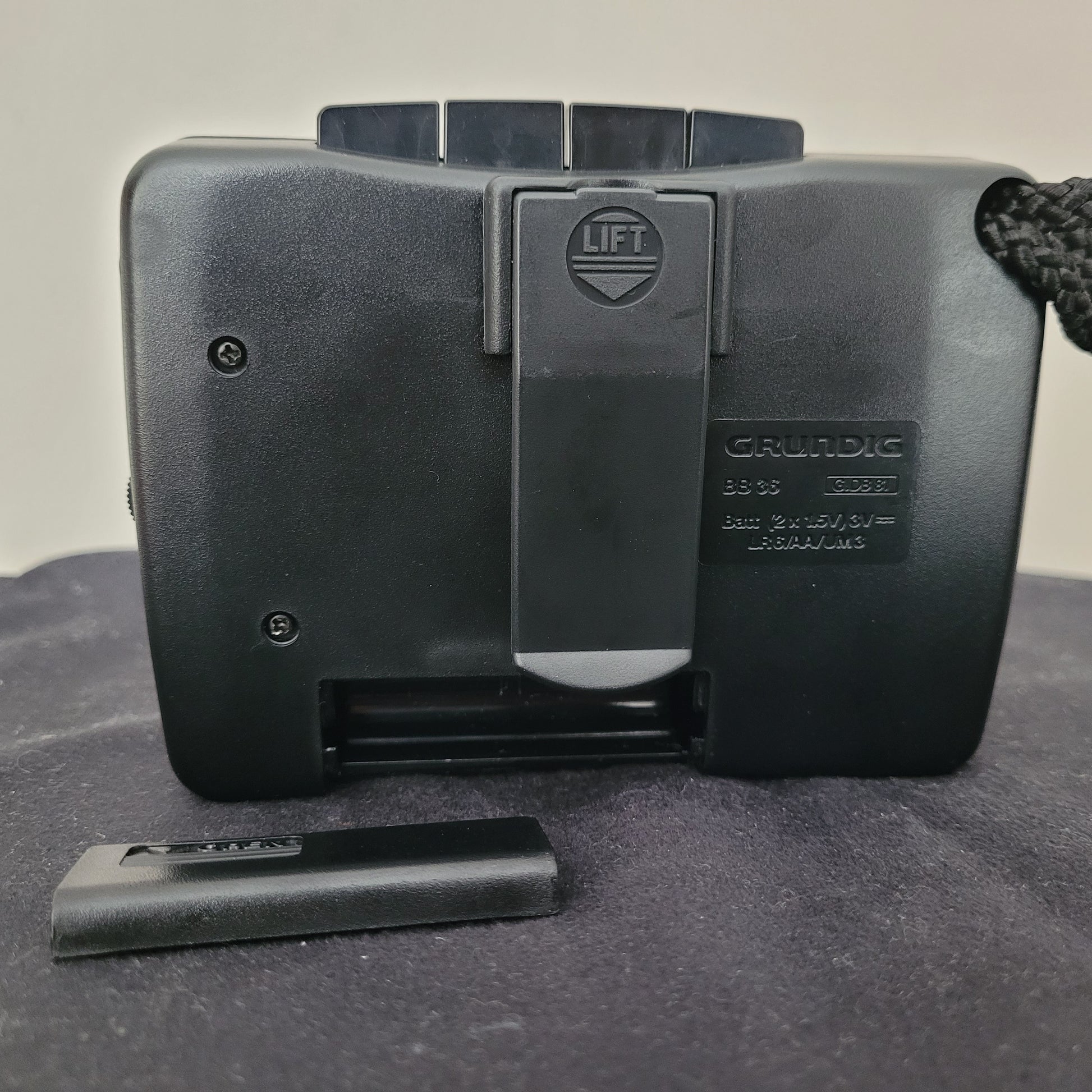 Rückseite des Grundig Vintage Walkman BB 35 mit geöffnetem Batteriefach für 2× AA-Batterien, Clip mit „LIFT“-Markierung und technischer Beschriftung – klassisches Retro-Kassettengerät für analoge Musikliebhaber.