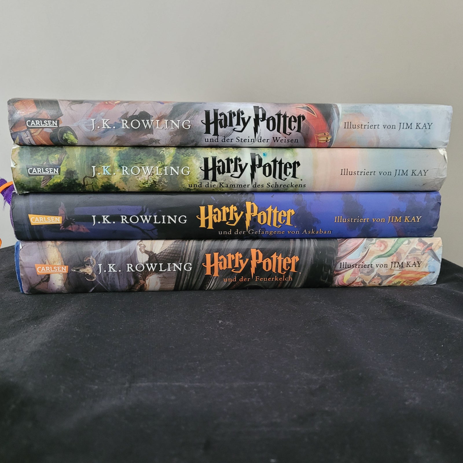 Auf dem Bild sind 4 Teile der Harry Potter Bücher Serie zu sehen. Es sind die Teile: Harry Potter und der Stein der Weisen,Harry Potter und der Kammer des Schreckens,Harry Potter und der Gefangene von Askaaben und Harry Potter und der Feuerkelch. Illustrierte Bilder von Jim Kay.