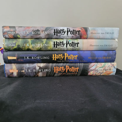 Auf dem Bild sind 4 Teile der Harry Potter Bücher Serie zu sehen. Es sind die Teile: Harry Potter und der Stein der Weisen, Harry Potter und der Kammer des Schreckens, Harry Potter und der Gefangene von Askaban und Harry Potter und der Feuerkelch. Illustrierte Bilder von Jim Kay.