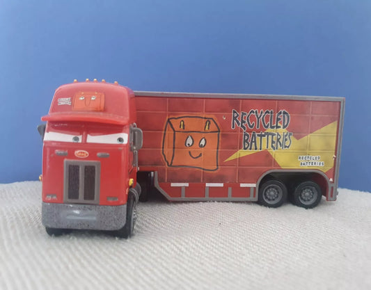 Disney Pixar Cars - Jerry Recycled Batteries 'Race o Rama' Spielzeug-LKW. Detailreich gestalteter roter LKW mit der Aufschrift 'Recycled Batteries', inspiriert von der beliebten 'Cars'-Filmreihe. Perfekt für Kinder und Sammler. Blauer Hintergrund.