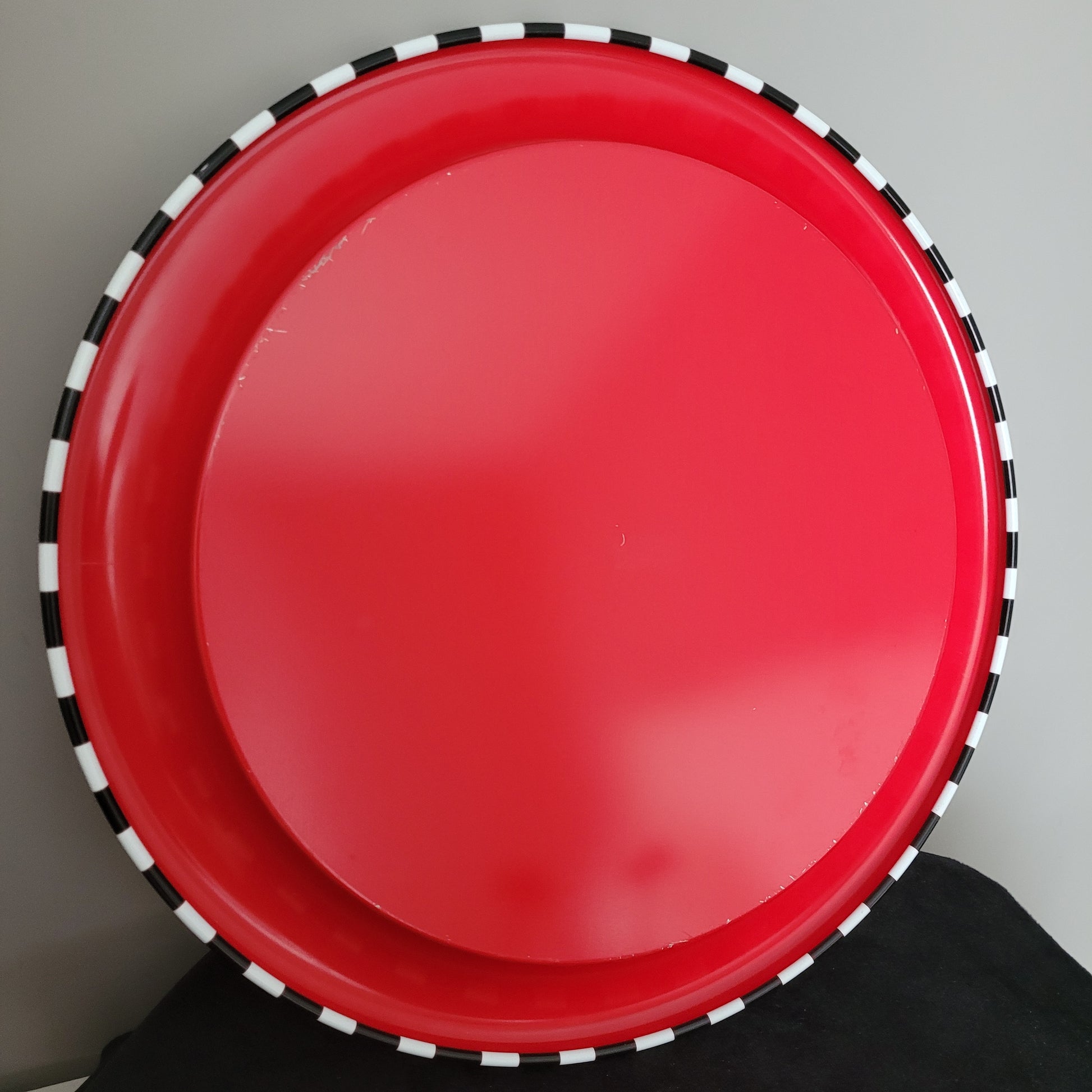 Vintage Trinkglas Set – Unterseite des Tabletts, rote Fläche auf schwarzer Oberfläche Das Bild zeigt die Unterseite des Tabletts aus dem Vintage Trinkglas Set, mit einer markanten roten Fläche auf schwarzer Oberfläche. Die Kombination aus Retro-Farben unterstreicht den nostalgischen Charakter des Sets und sorgt für einen stilvollen Akzent.