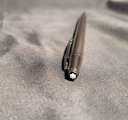 Nahaufnahme des Drückers eines Vintage Montblanc Noblesse Kugelschreibers. Zu sehen ist der charakteristische weiße Montblanc-Stern (Snowcap) auf schwarzem Grund sowie der präzise gearbeitete Metallclip des Slimline-Modells aus den 70er/80er Jahren.