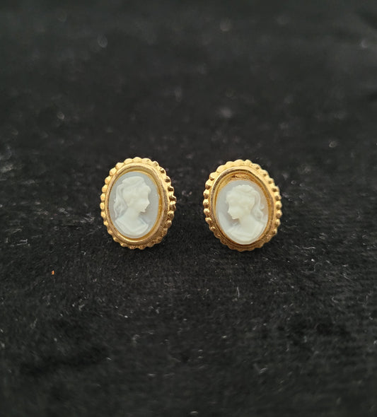 Antike goldene Ohrringe mit Kamee-Motiv auf schwarzem Hintergrund. Die Ohrringe zeigen das seitliche Profil einer Frau und sind von einem goldenen, perlenartigen Rand umgeben. Perfekt für Liebhaber von Vintage-Schmuck.