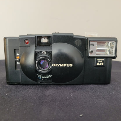 Olympus XA2 Kleinbild-Sucherkamera in Schwarz, mit zentralem Objektiv und elektronischem Blitzgerät A11. Beliebtes Vintage-Modell für analoge Fotografie-Enthusiasten.