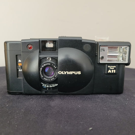 Kompakte analoge Kleinbild-Sucherkamera Olympus XA 2 in Schwarz mit aufgesetztem Blitzgerät A11.