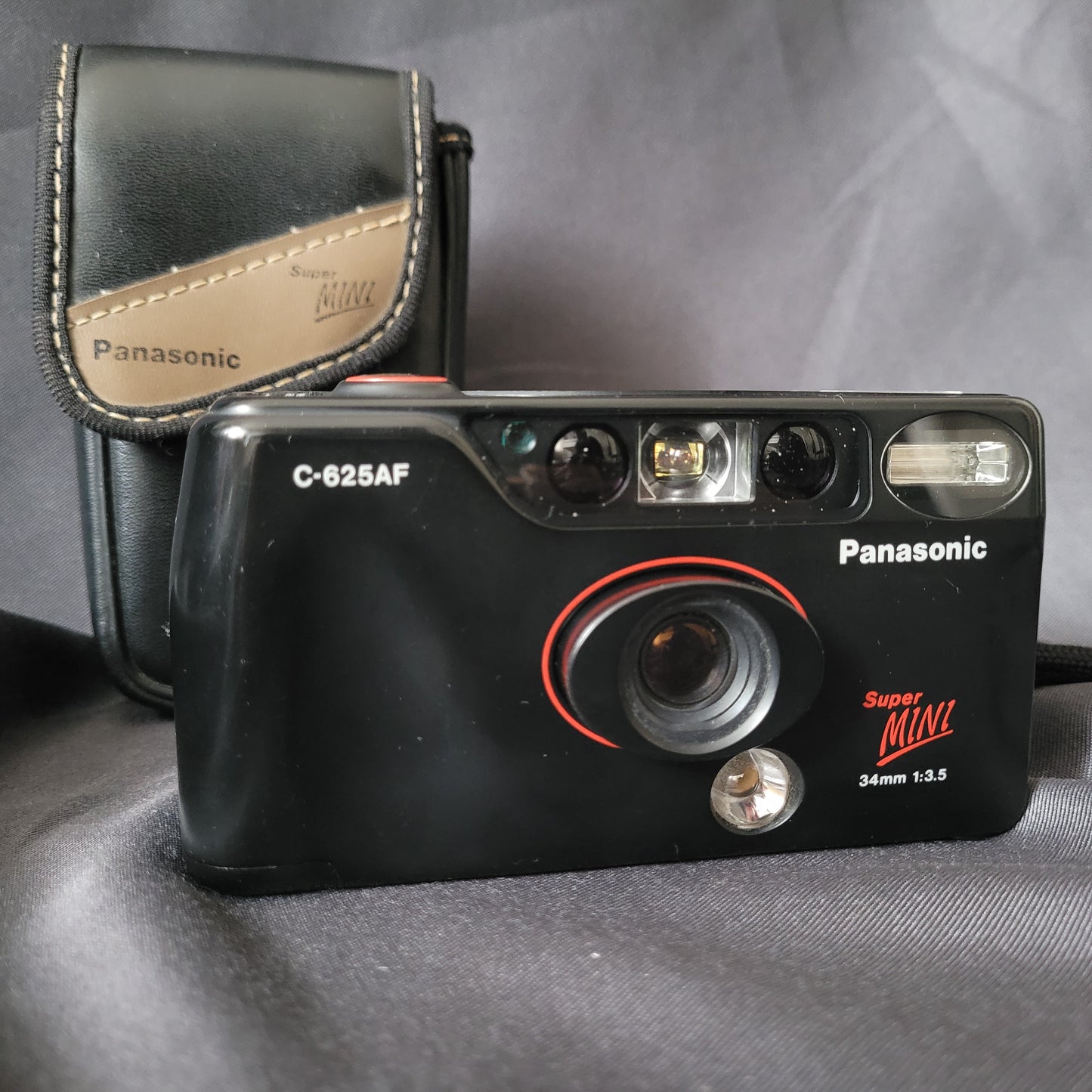 Panasonic Super Mini C-625AF Vintage Analogkamera mit 34mm f/3.5 Objektiv, eingebautem Blitz und Originaltasche – kompakte 35mm Point-and-Shoot Kamera für Sammler klassischer Fototechnik.