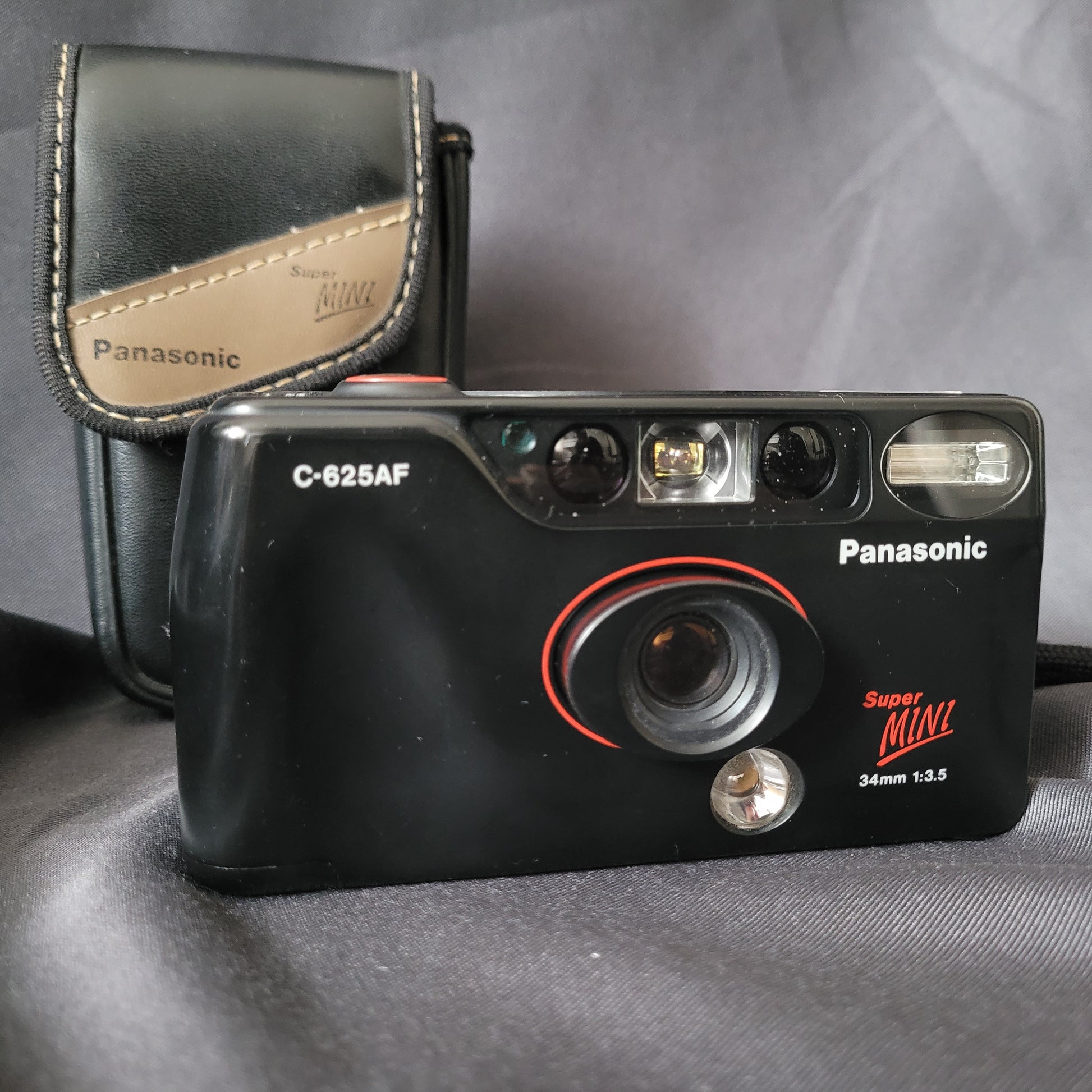 Panasonic Super Mini C-625AF Vintage Analogkamera mit 34mm f/3.5 Objektiv, eingebautem Blitz und Originaltasche – kompakte 35mm Point-and-Shoot Kamera für Sammler klassischer Fototechnik.