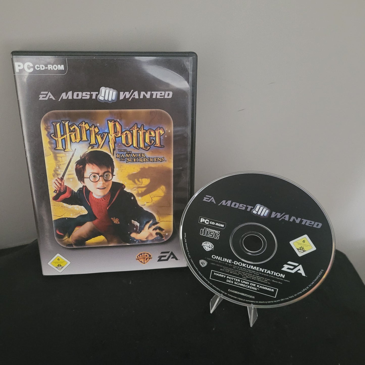 Zu sehen ist das PC von EA Sports Harry Potter und die Kammer des Schreckens, auf schwarzem Unter- und grauem Hintergrund.