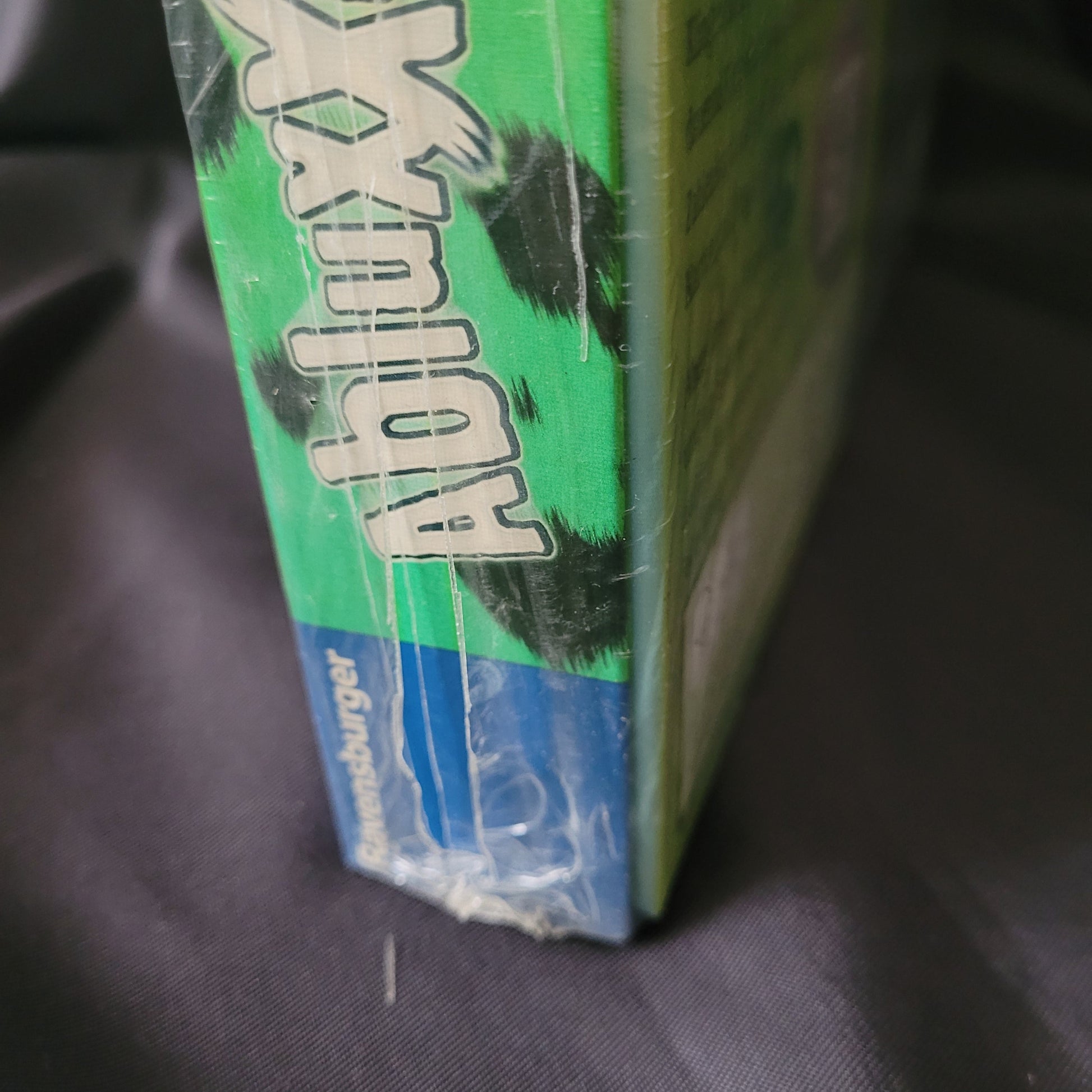 Phase 10 + Abluxxen 2in1 Ravensburger Kartenspiele – Seitenansicht – Neu OVP – EAN 4049817651452, Kunststofffolie mit kleinem Riss sichtbar, detailreiche Nahaufnahme der Verpackung.
