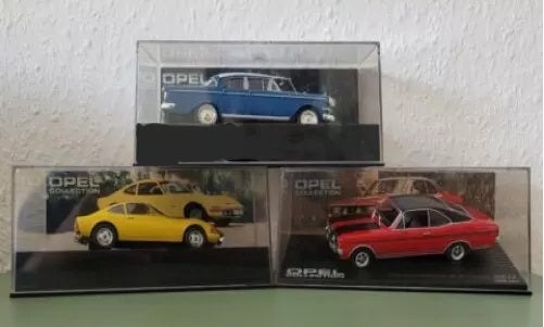Drei Modellautos der Opel Collection in durchsichtigen Kunststoffvitrinen, gestapelt: blauer Kapitän PI Limousine, gelber Opel GT, roter Opel Commodore.
