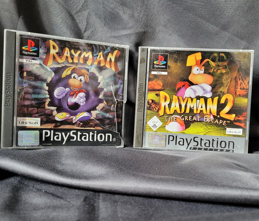 Zwei PlayStation 1 Spiele: Rayman und Rayman 2: The Great Escape inklusive Anleitungen und Discs.