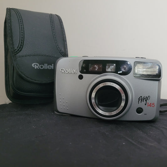 Rollei Prego 145 analoge Kompaktkamera in silber mit Objektiv (38-145mm) und Blitz. Inklusive schwarzer Tasche mit Rollei-Logo. Perfekt für Vintage-Fotografie