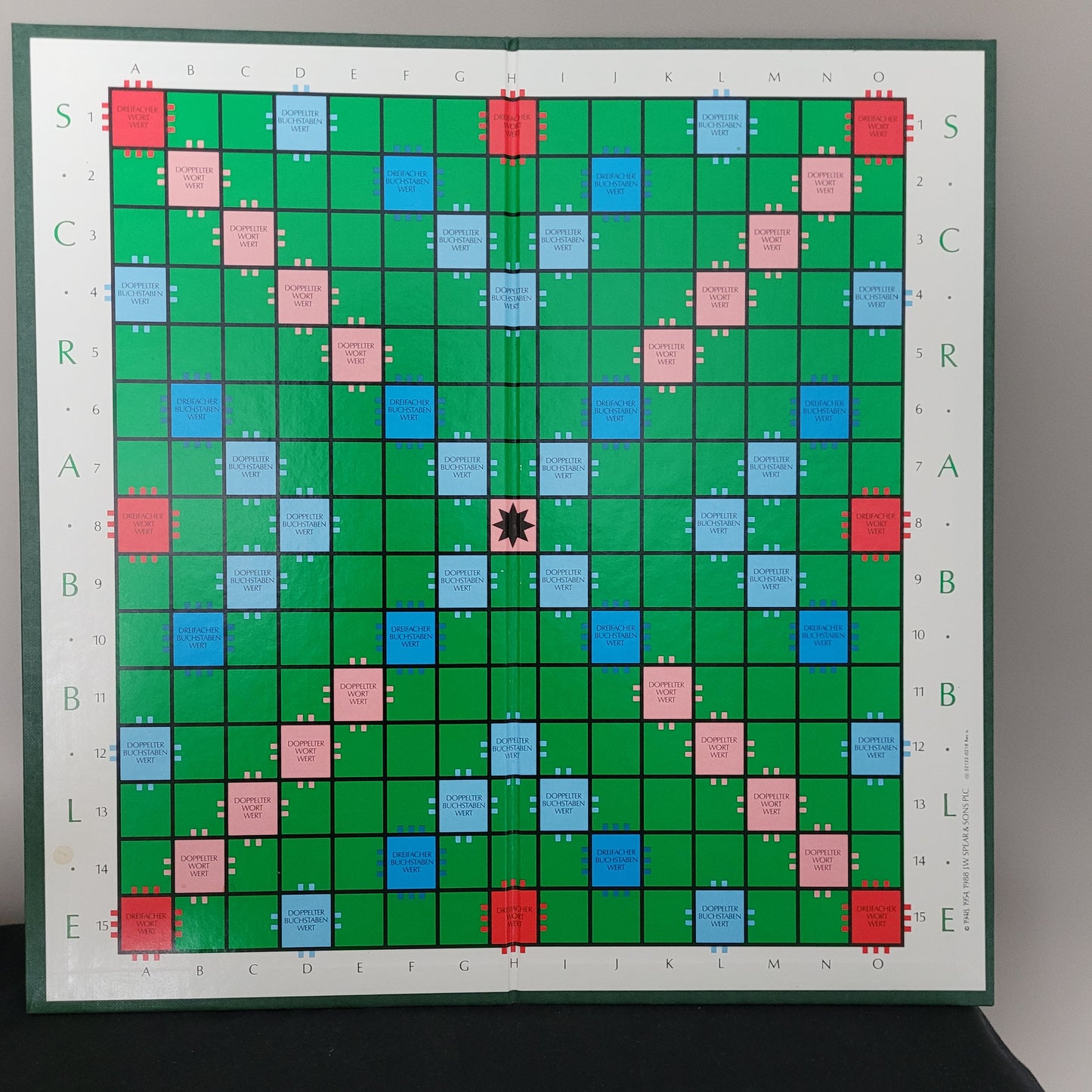 Spielbrett der Scrabble Original Club Sonderausgabe. Quadratisches Raster aus 15x15 Feldern mit grünen, blauen, rosa und roten Farbfeldern. Sonderausgabe für Kreuzworträtsel-Fans.