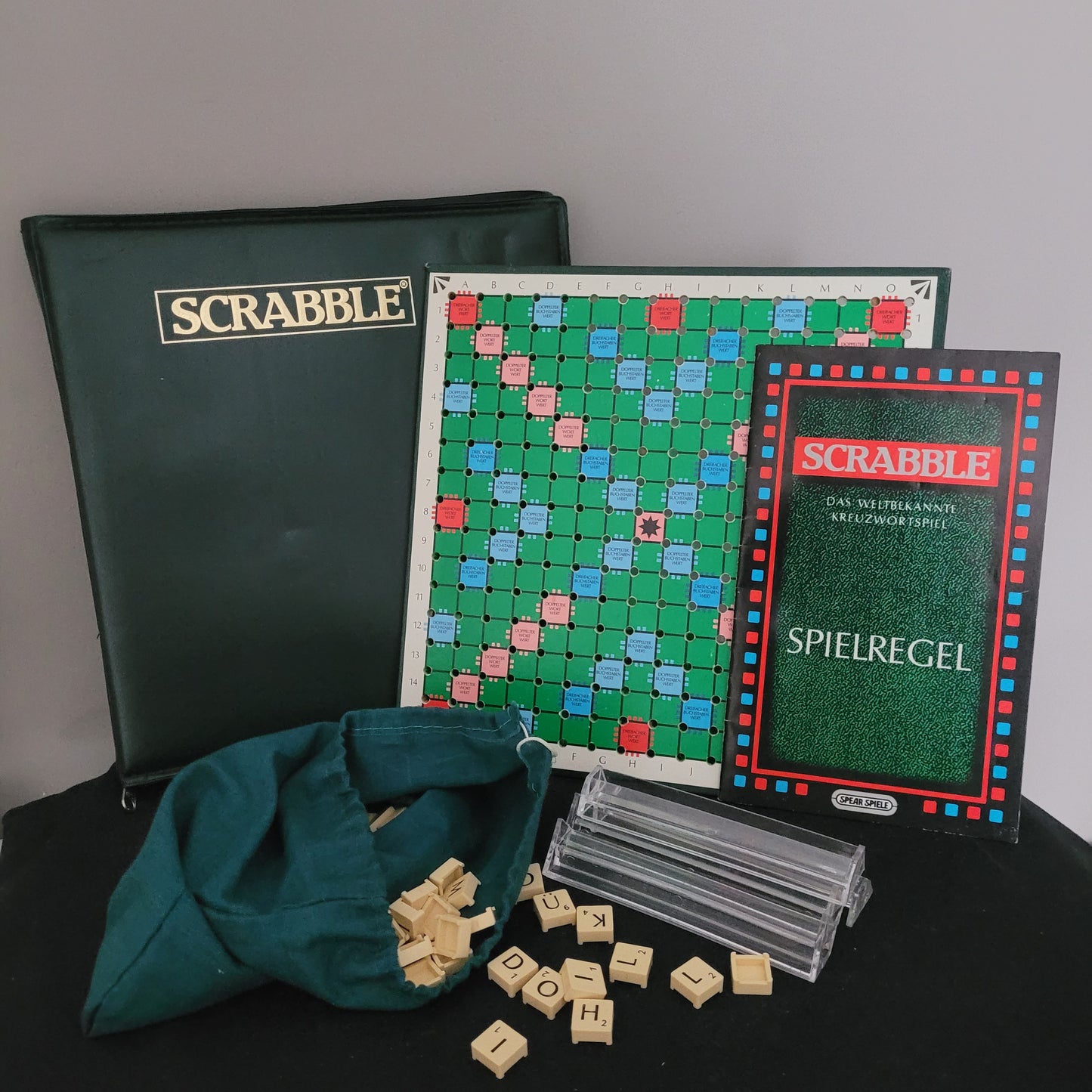 Scrabble-Spielset mit grünem Kunstlederkoffer, aufgeklapptem Spielbrett, Spielanleitung, Buchstabenbeutel, Buchstabensteinen und Aufstellern – Vintage Sammlerstück.