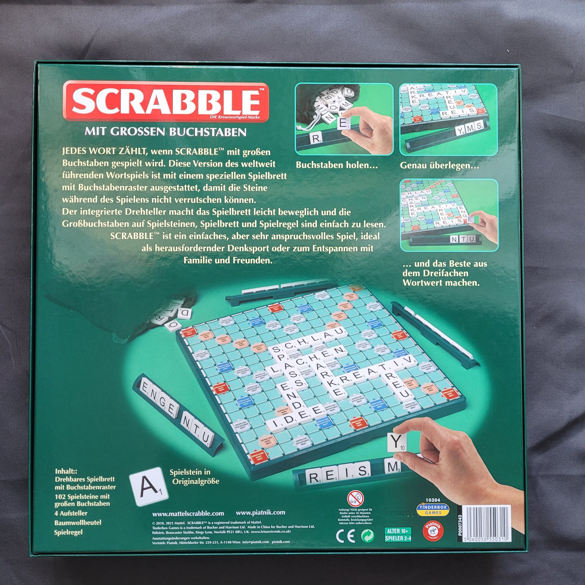 Das Bild zeigt die Rückseite des Scrabble mit großen Buchstaben – ein hochwertiges Gesellschaftsspiel von Piatnik & Mattel. Zu sehen sind die Produktinformationen und Details zur Spielausstattung sowie die eindeutige EAN 5060058550310, die eine präzise Identifikation ermöglicht. Die Rückseite bietet eine Übersicht über die enthaltenen extra großen Buchstabensteine sowie die klassischen Scrabble-Spielregeln. Der Hintegrund ist schwarz.