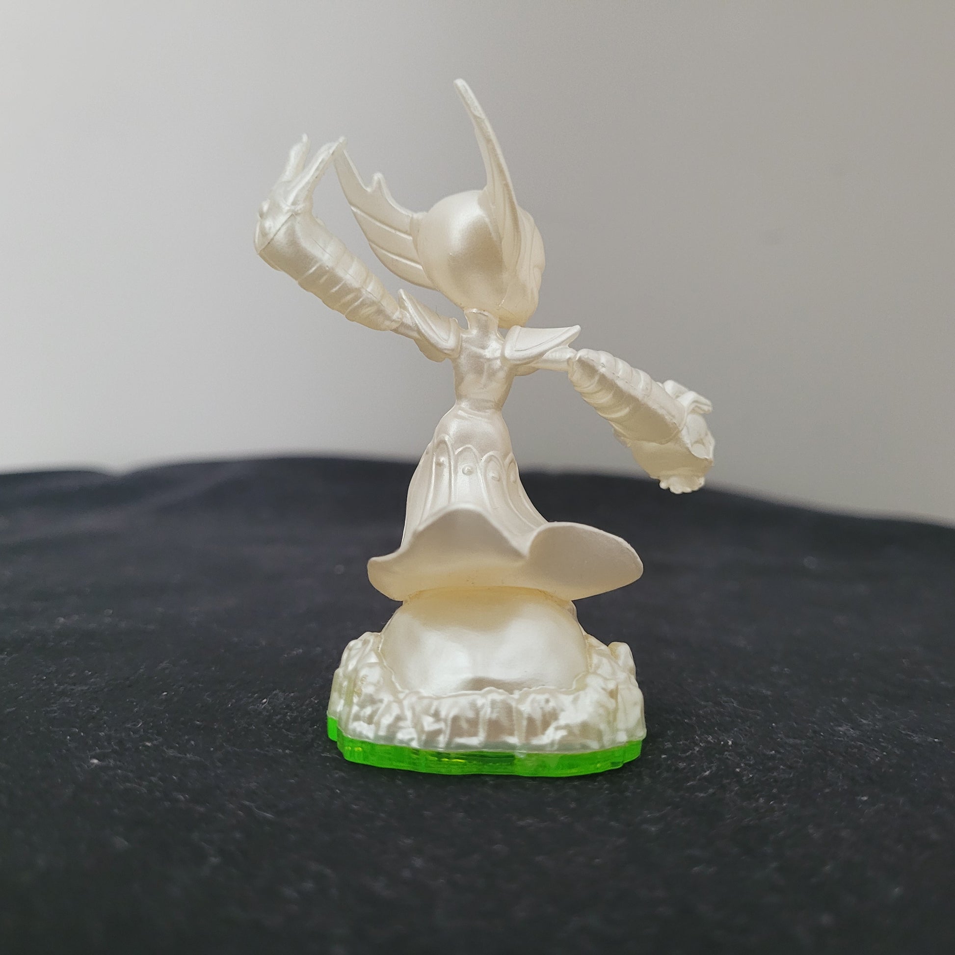 Rückansicht der Skylanders Pearl Hex Figur mit perlmuttweißem Finish, Flügelhelm und Rüstung auf grünem Sockel – seltenes Sammlerstück und Rarität