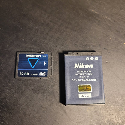 Eine Speicherkarte des Herstellers Medion und die Batterie der Kamera.
