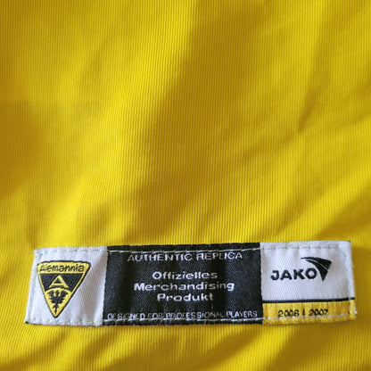 Etikett mit folgendem Hinweis istzu sehen: Authentic Replica; Offizielles Merchandising Produkt. Zusätzlich ist das Logo des TSV Alemannia Aachen und des Herstellers Jako zu sehen.