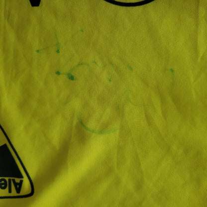 Unterschrift bzw. Signatur eines Spielers des TSV Alemannia Aachen aus der Bundesliga Saison 2006/2007, welche kaum noch erkennbar ist ,ist zu sehen. In grün und der Hintergrund ist gelb.