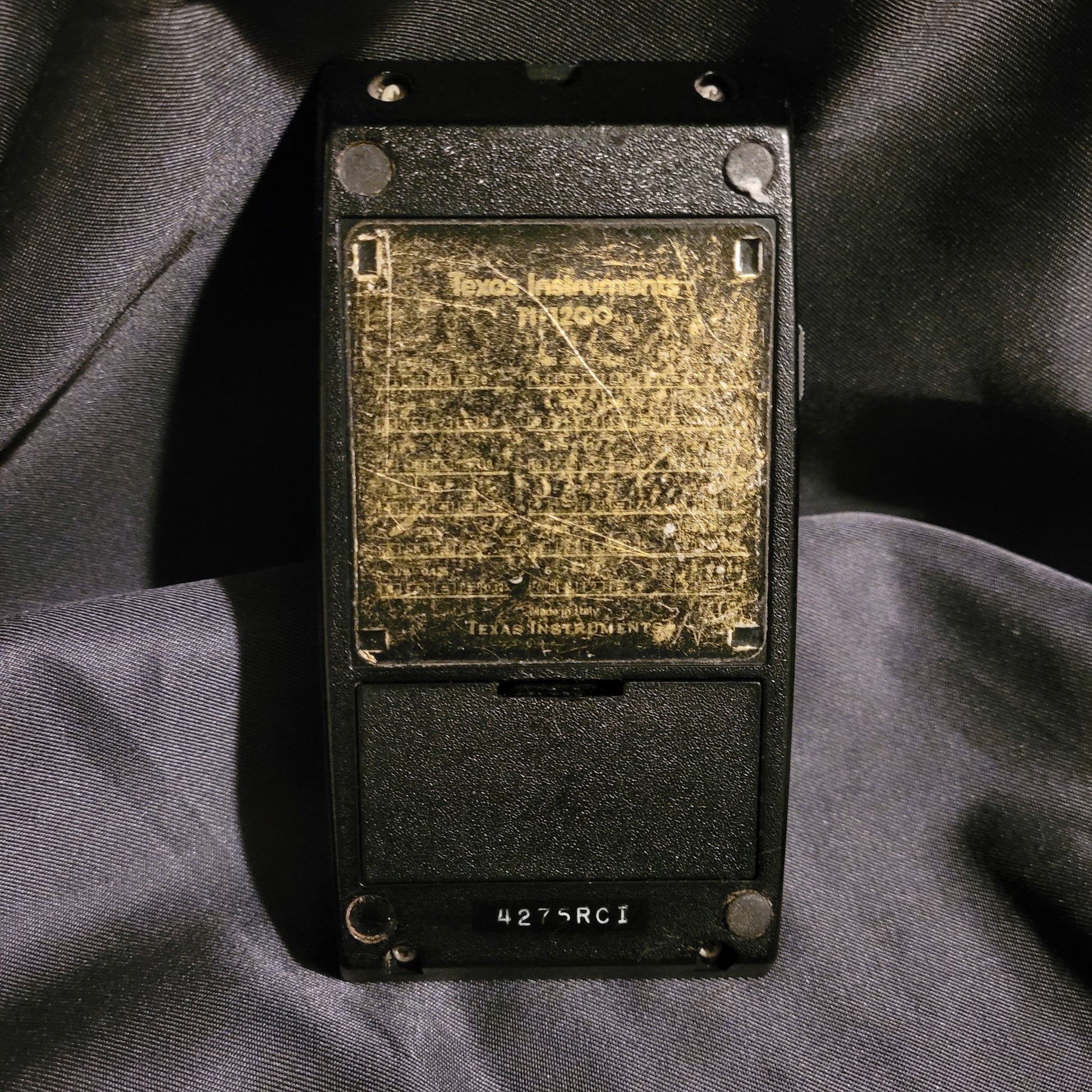 Rückansicht des TI-1200 mit sichtbarer Patina und der 'Made in Italy' Kennzeichnung von Texas Instruments.