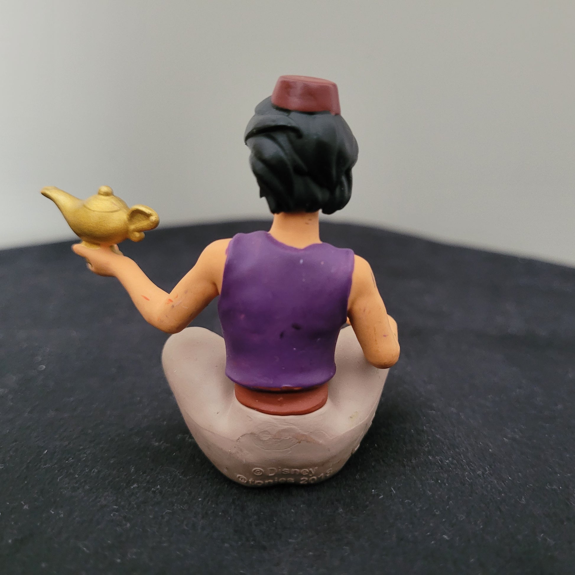 Tonie / Tonies Figur Aladdin. Zu sehen ist die Rückseite auf schwarzer Oberfläche und grauem Hintergrund.